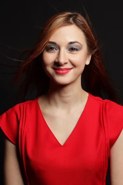 The beautiful natural young smiling woman of the brunette carrying a red dress.