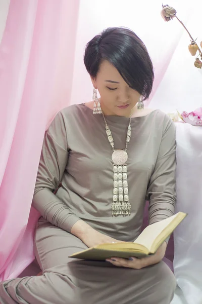 Beautiful Japanese girl reading an interesting book.