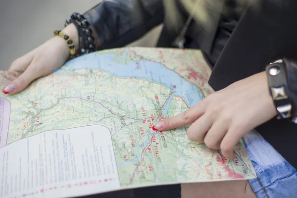 The lady examines the map and selects a route traveling.