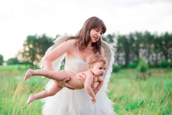 A young mother in the image of an angel embraces, protects your baby. Stylized fairy tale characters