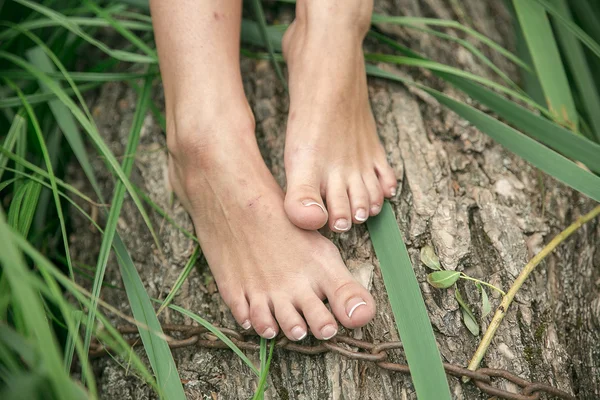 The girls feet from abrasions and bruises on the tree with a chain. Social issues, care of the body.