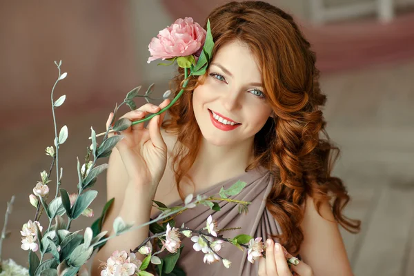Portrait of a beautiful red-haired laughing girl with blue eyes
