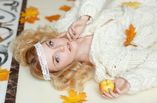 Portrait of a gentle sensual blonde girl lying on the floor with