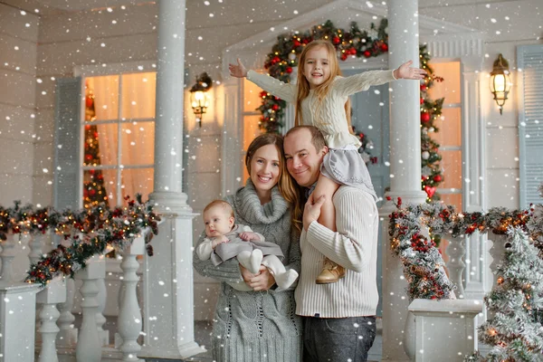 Beautiful happy family with little girl in knitted sweaters are