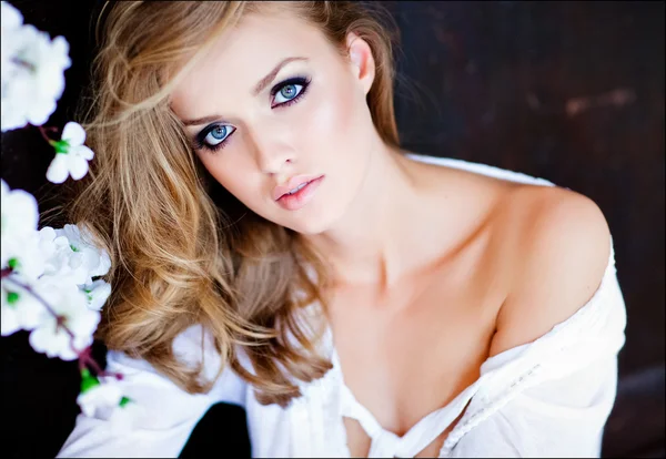 Portrait closeup sensual blonde girl with blue eyes in white shirt