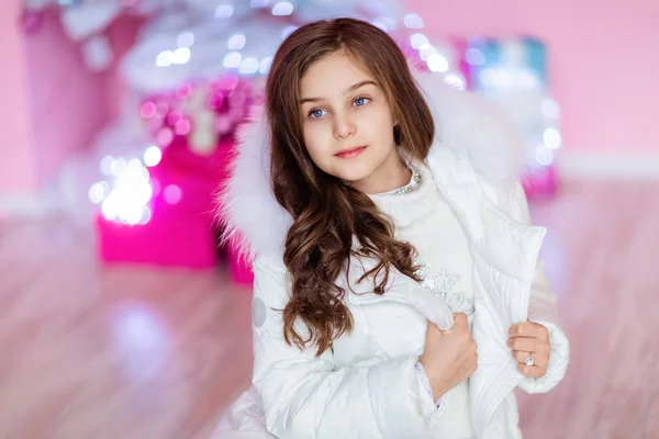 Very cute long-haired young girl with blue eyes in a white coat