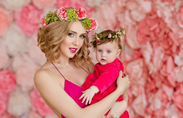 Beautiful slim blonde mom in red dress and a wreath of flowers i