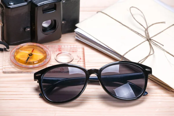 Sunglasses, compass, vintage film camera and a bunch of old lett