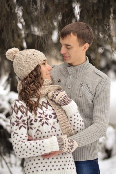 Happy woman, kissed by his boyfriend in the forest. Handsome man kiss her beloved, enamoured, attractive, cheerful, smiling girl in rose cheek. Lovers.