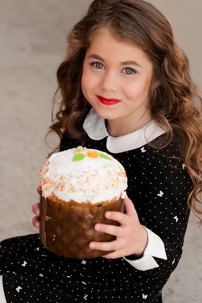 Fashionable portrait of sweet tooth beautiful, attractive, cheerful, stylish girl with wonderful white smile, makeup holding her birthday cake and celebrating her birthday outdoors