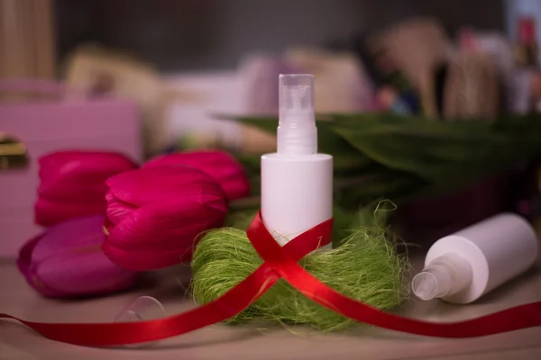 White spray bottle cosmetic on tulip blur background