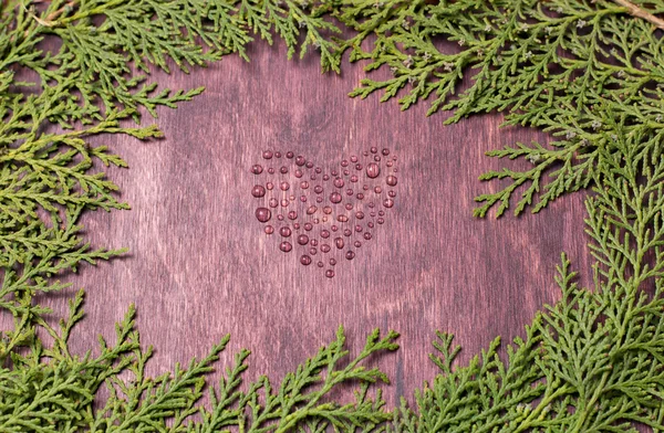 Symbol of love heart from waterdrops on wood wall