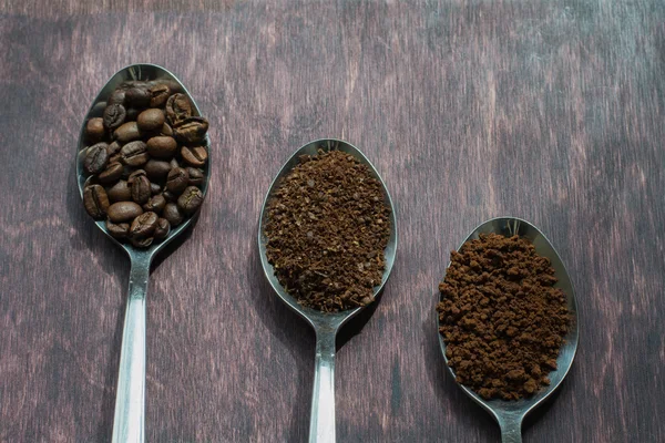 Three stages of spoons in coffee - beans, ground, instant