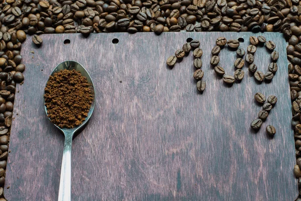 Soluble coffee in a spoon on wooden background.