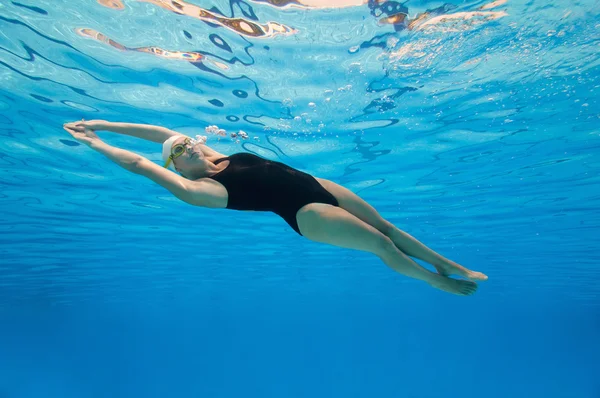 Woman swimming under the water surface