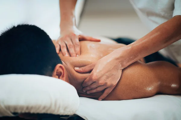 Physical therapist massaging shoulder