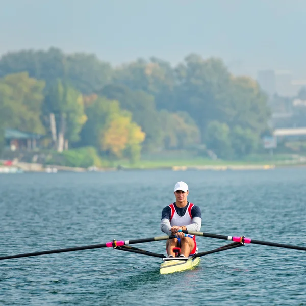 Athlete rowing training on lake