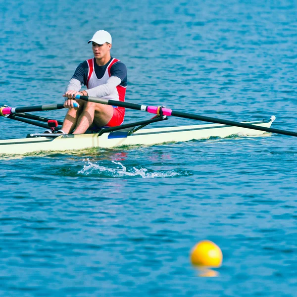 Single scull rowing on lake