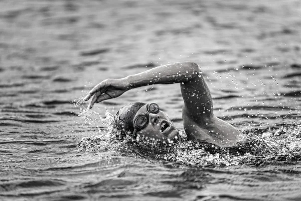 Triathlon female competitor swimming.