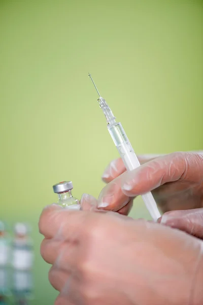 Nurse holding syringe and vaccine vial