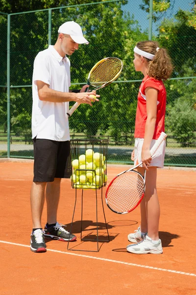 Tennis coach instructing player