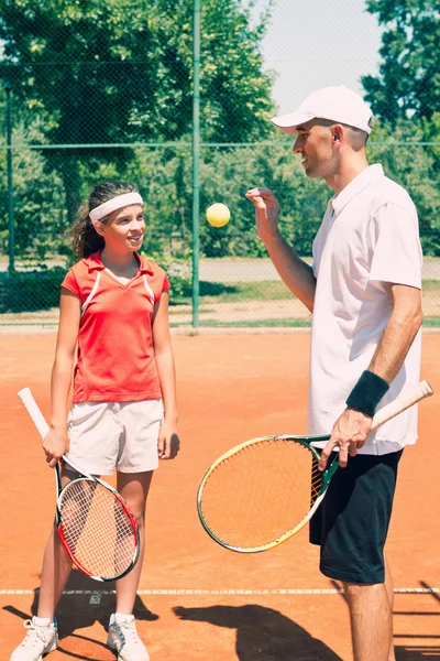 Tennis coach with junior player