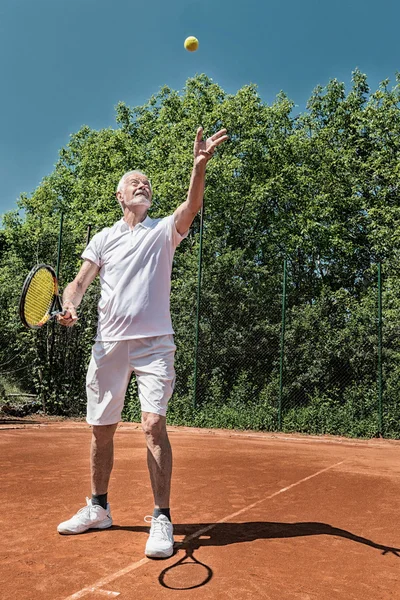 Senior tennis player serving