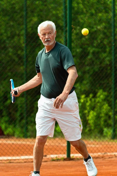 Senior man playing tennis