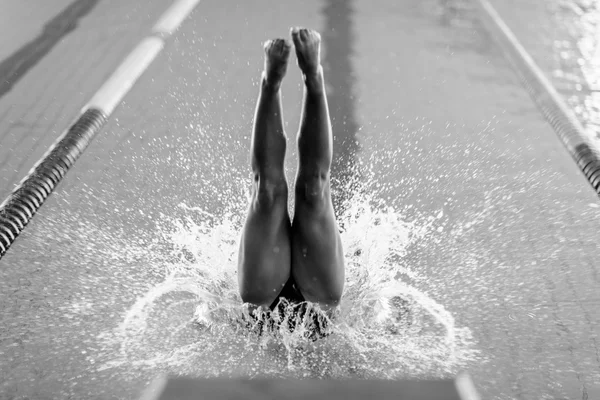 Female swimmer jumping into the pool