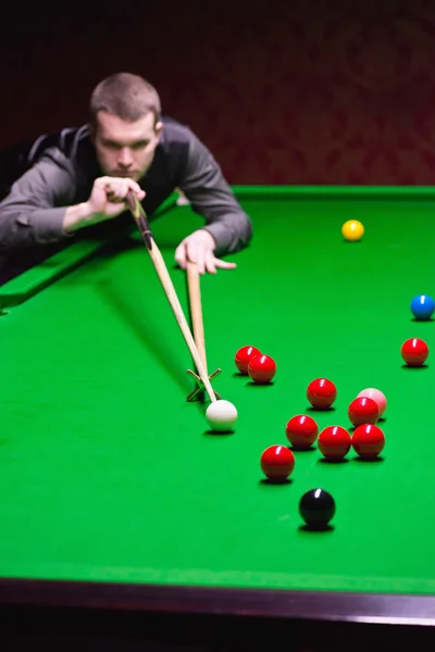 Snooker player addressing red ball
