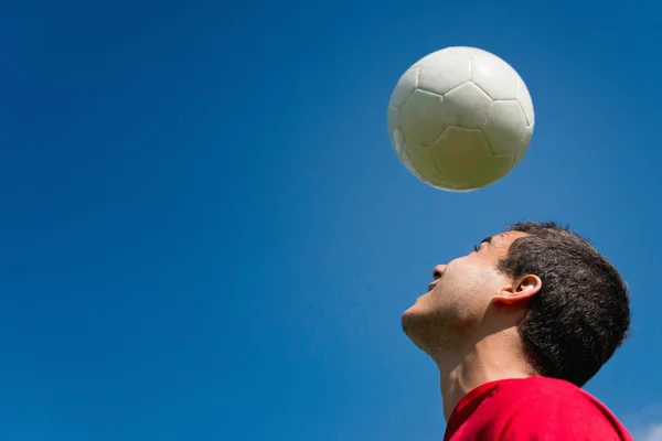 Soccer player with ball over head