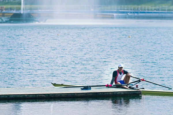 Sportsman having break after rowing