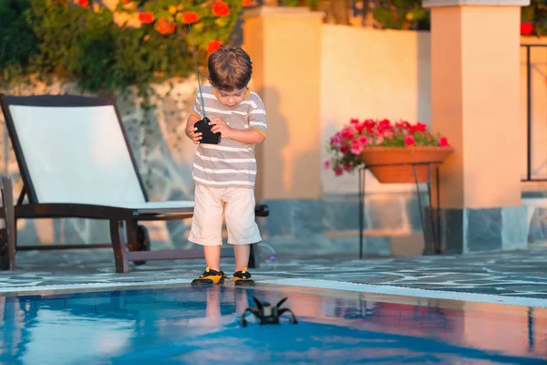 Cute boy playing with remote control boat