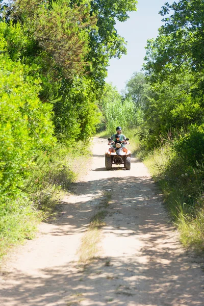 Son and mother driving quad bike