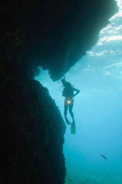 Scuba diver at entrance to underwater cave