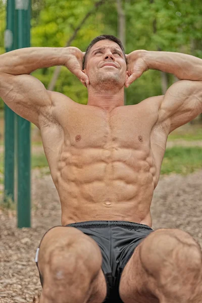 Muscular young man doing crunches