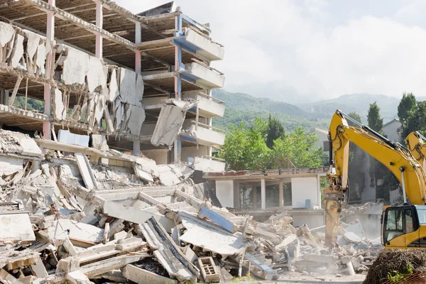 Construction machines demolishing building