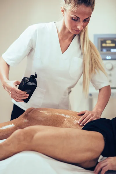 Female physical therapist massaging man