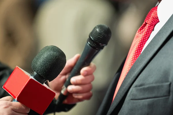 Journalists with microphones interviewing