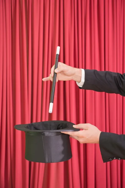 Magic trick with wand and hat