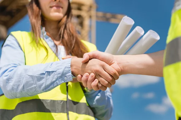 Architect and building contractor shaking hands