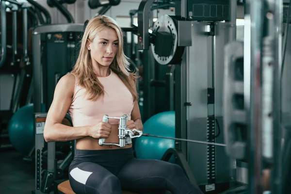 Woman exercising on rowing machine in gym