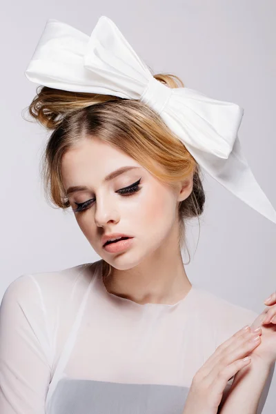 Portrait of young beautiful bridal with natural beauty, nude makeup, big white bow in the  hair