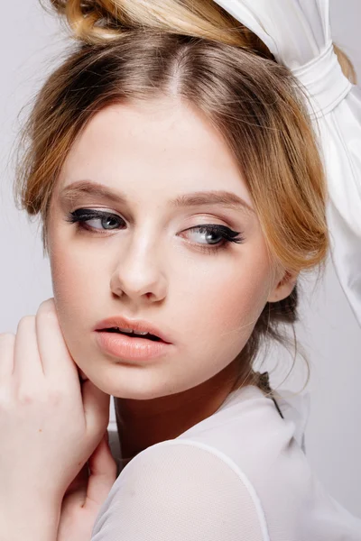 Portrait of young beautiful bridal with natural beauty, nude makeup, big white bow in the  hair