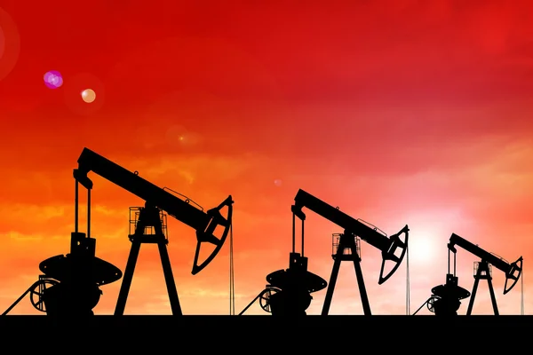 Silhouette of oil pumps at sunset.