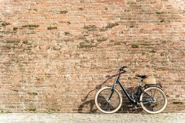 Black retro vintage bicycle with old brick wall.