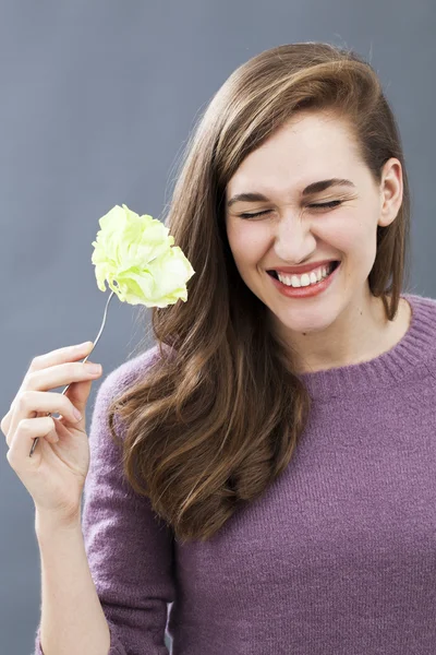 Joyful 20s girl happy to eat appetizing green salad as fresh diet