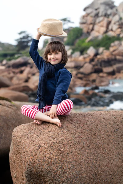 Vacation postcard concept with smiling child raising hat for hello