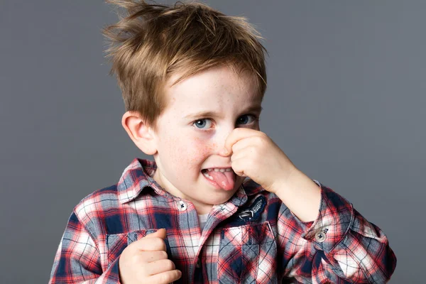 Young boy pinching his nose for sign of bad odor