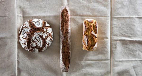Symmetrical still-life of three organic whole wheat breads